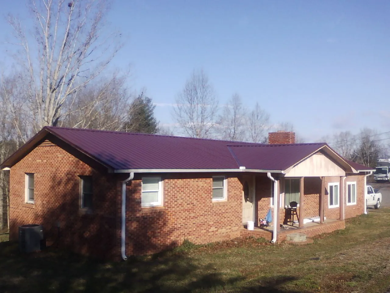 Burgundy metal roof on a brick ranch home with a new addition in Fort Washington