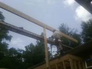 Carpenter setting a ridge beam over a new addition frame — Ice Dam Removal by Roofing Brothers in Fort Washington